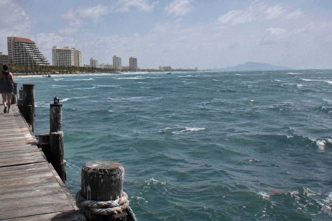 Open Caribbean water with a distant island on the horizon under a wide sky