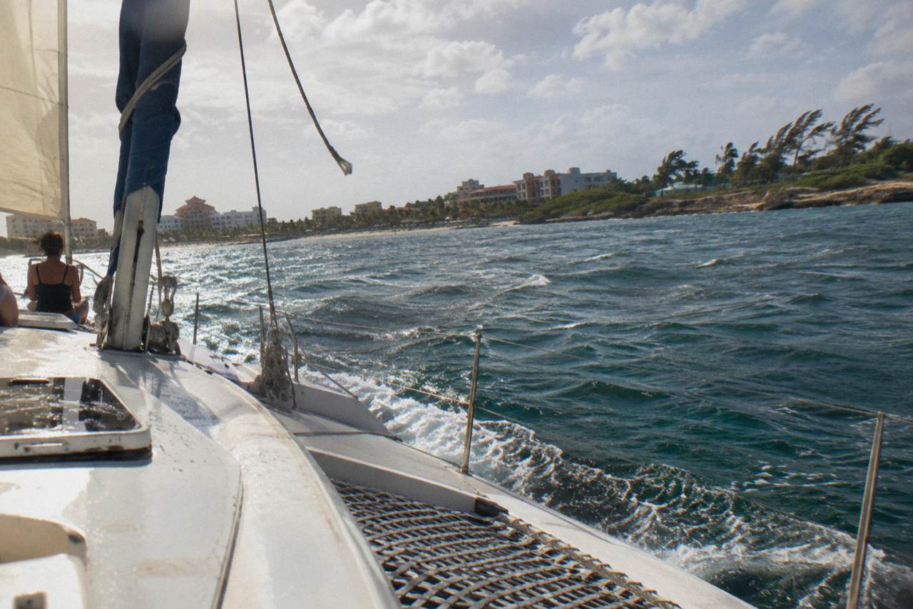 A catamaran sailing along the calm west coast of Aruba near Palm Beach at golden hour