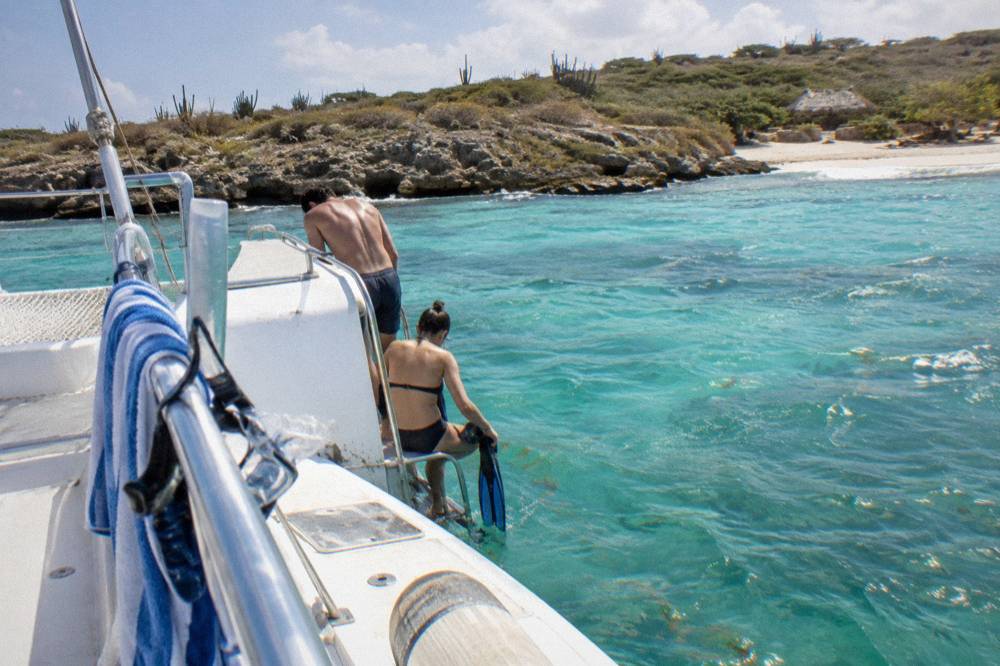 A catamaran moored near a snorkel site with passengers preparing to enter the water