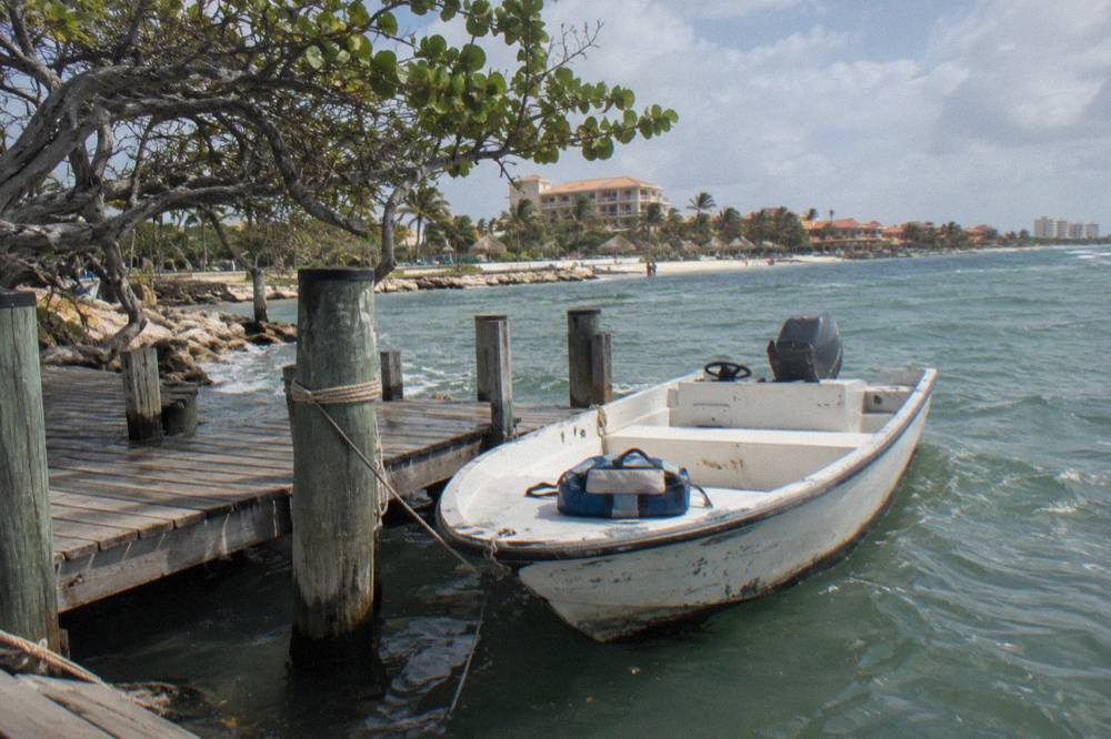 Small motorboat tied to a dock on calm water near Palm Beach
