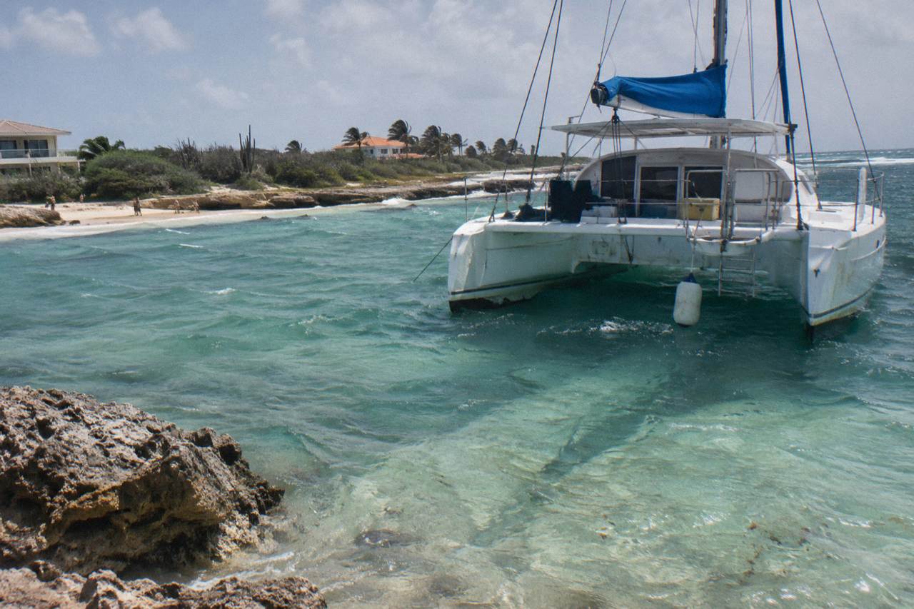 Catamaran anchored in calm turquoise water near the Aruba coastline