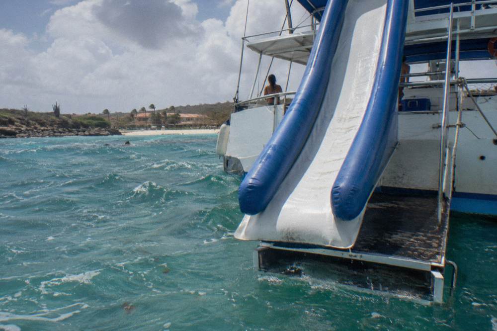 Water slide on a catamaran deck leading down to the sea