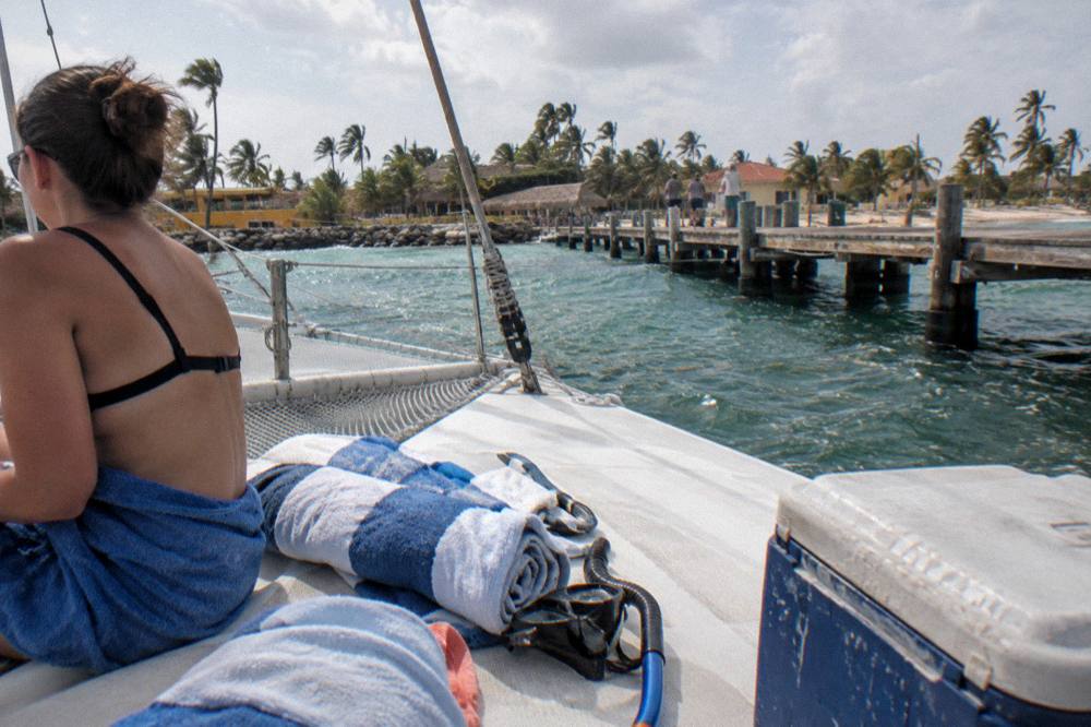 A catamaran deck with rolled towels, snorkel masks and a cooler ready for departure at a marina