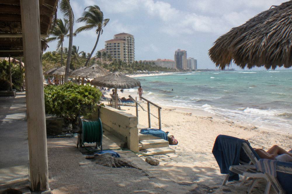 Beach umbrellas and calm water along a resort beachfront walkway