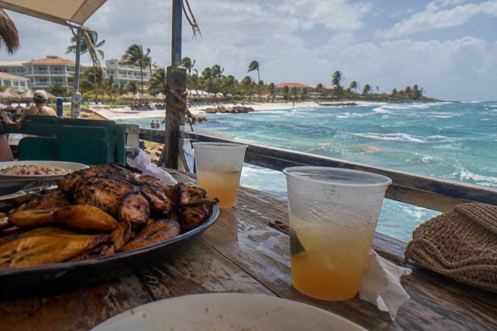 A serving of grilled food and drinks on a boat deck table under an awning