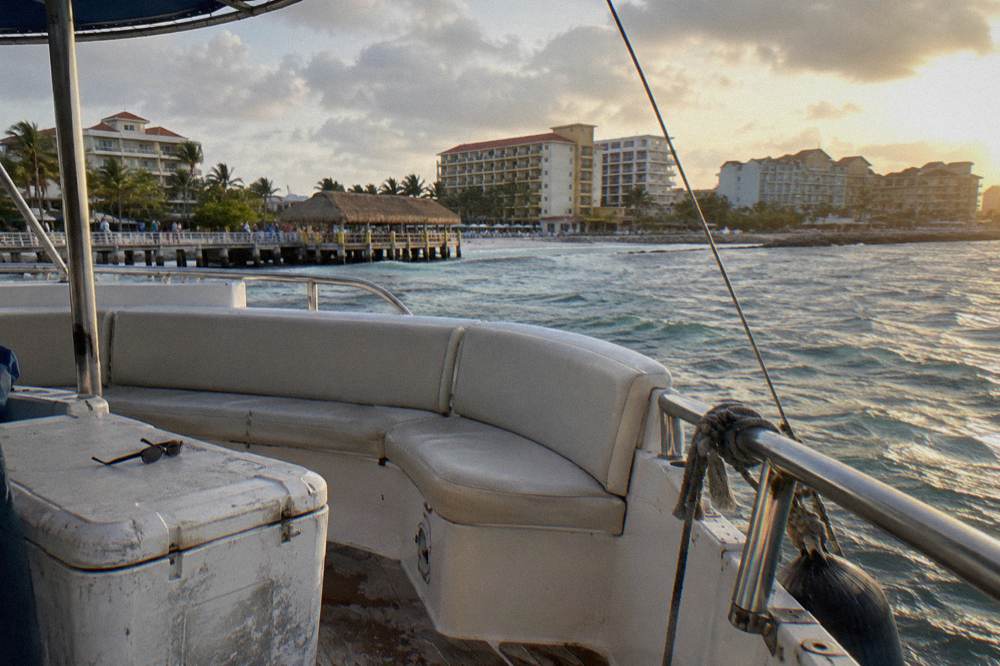 Open-air catamaran deck with seating and ocean view