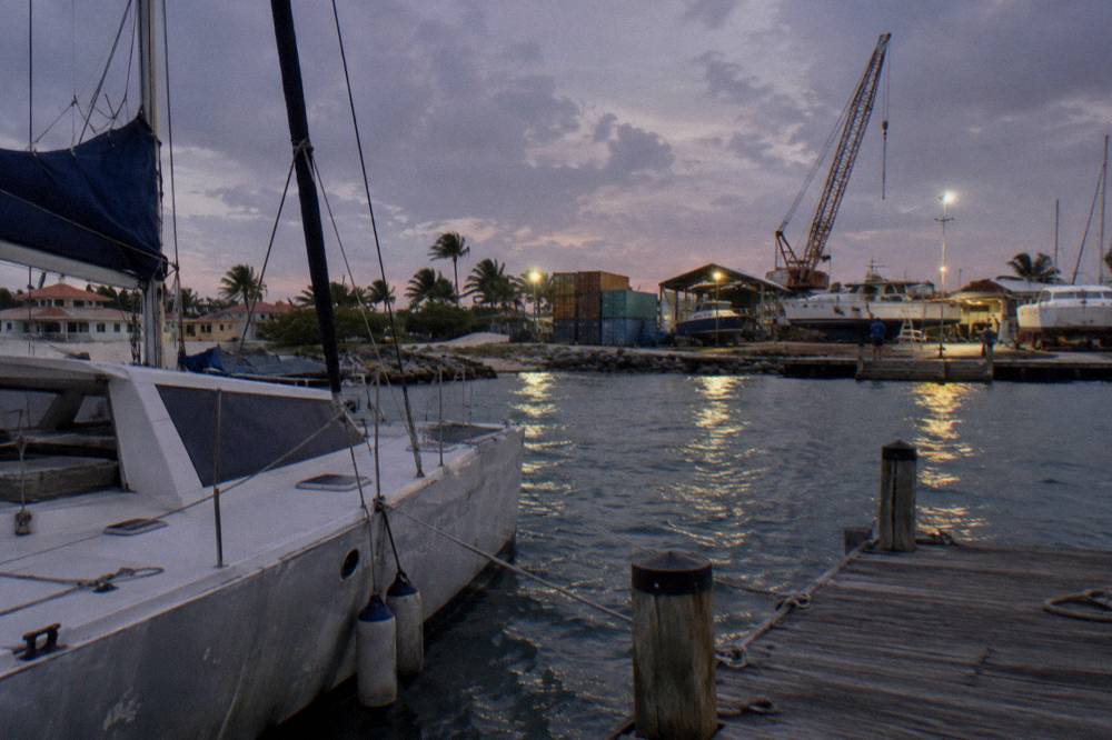 Catamaran moored at a marina in Oranjestad with boats and calm water