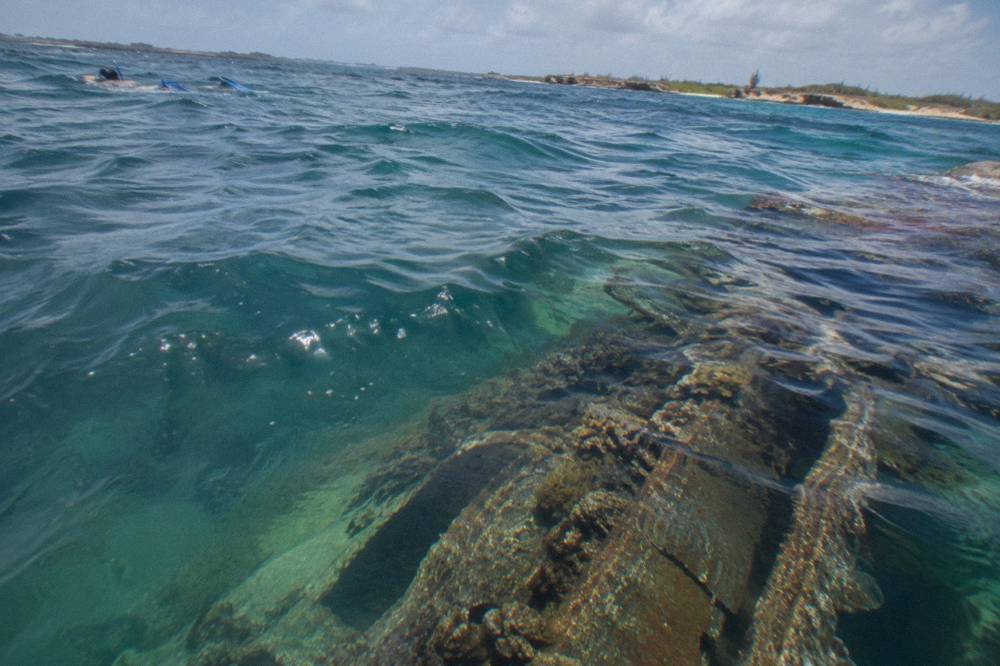 Shipwreck structure visible through clear blue water from the surface