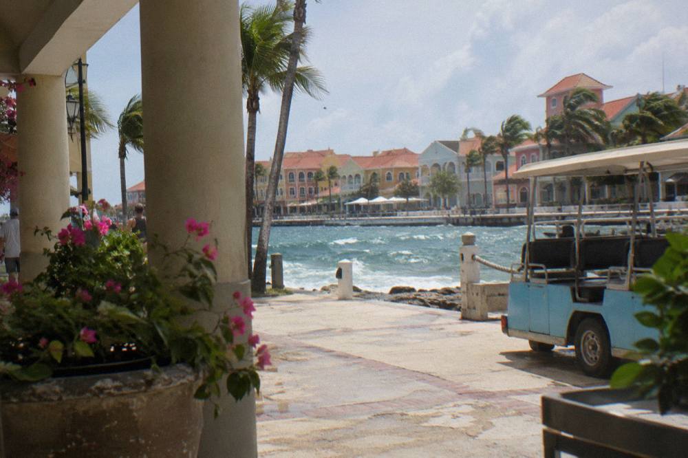 Pastel colored colonial buildings along a sunny waterfront street in Oranjestad