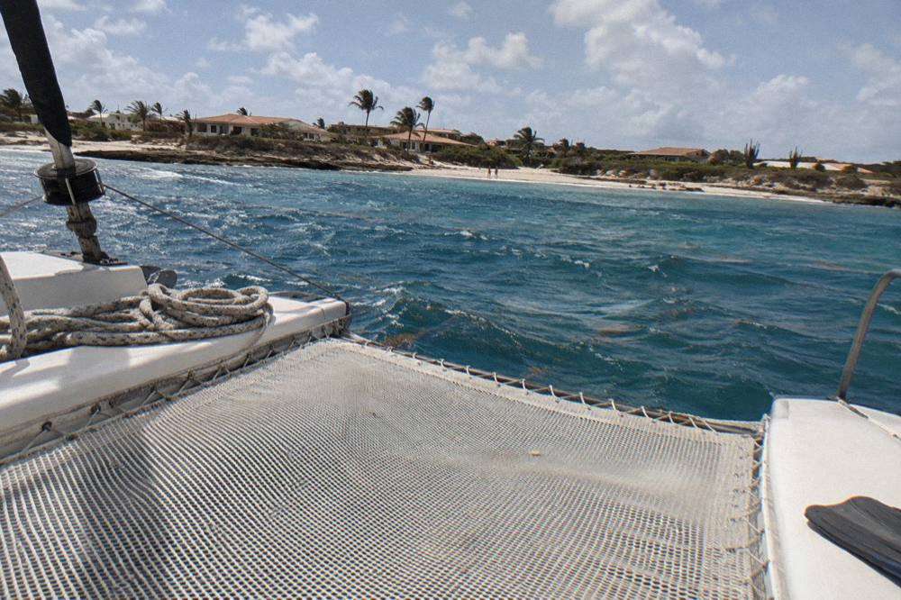 Morning sun over a catamaran net with calm open sea and scattered clouds