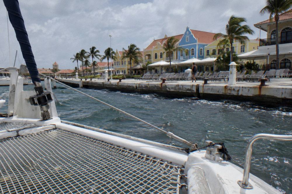 A group of deck chairs and a catamaran trampoline net on calm open water