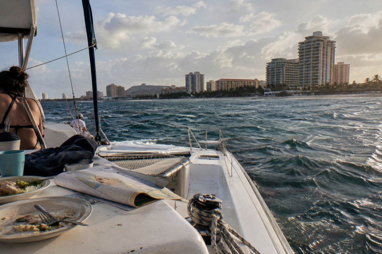 A catamaran anchored in calm turquoise water off the Aruba coast at late afternoon
