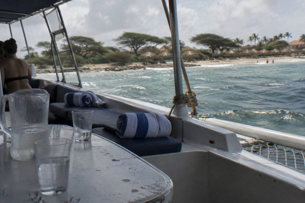 A shaded catamaran deck set with drinks and towels ready for passengers before departure