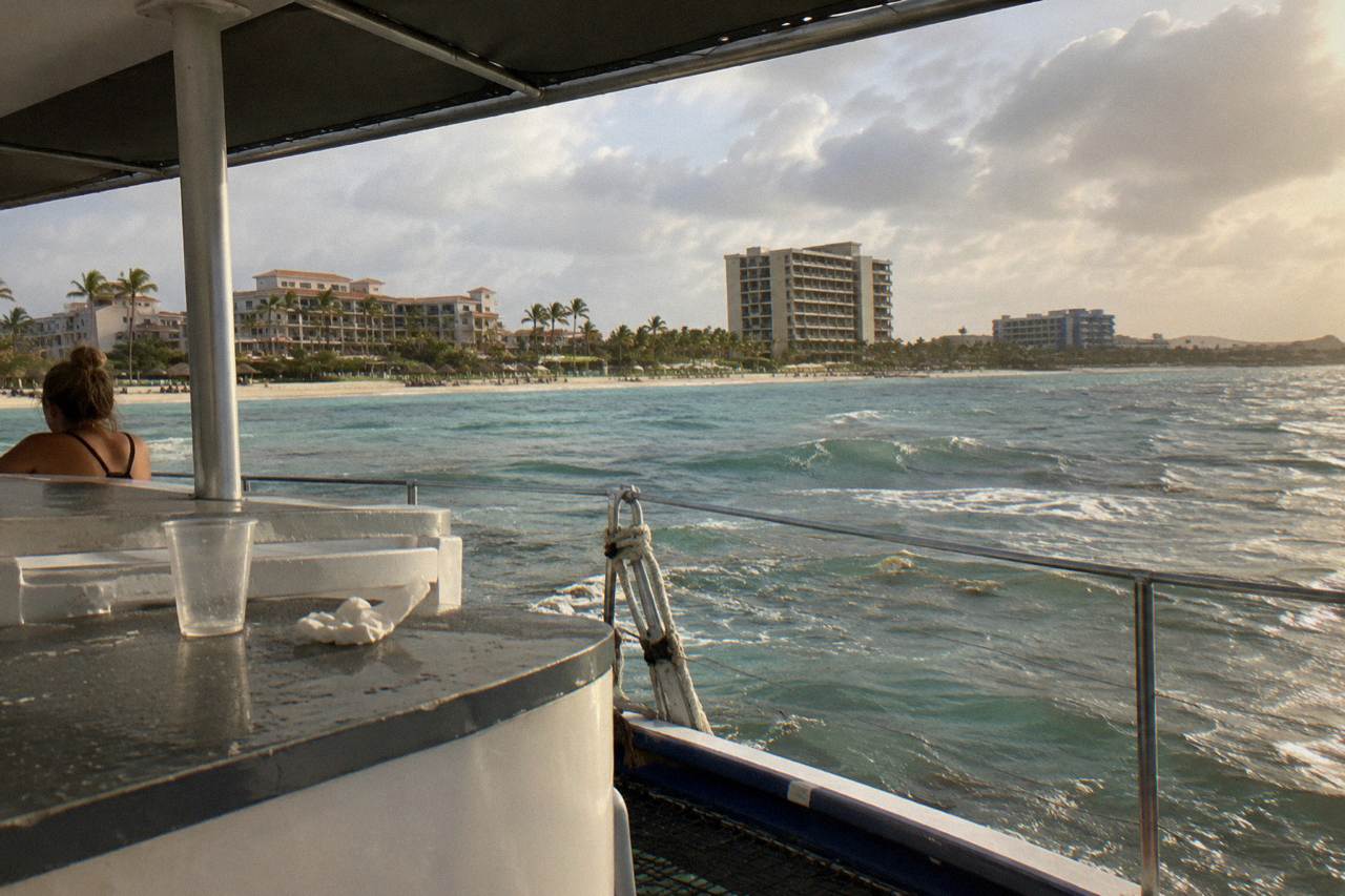 Catamaran deck at golden hour with calm Caribbean water and coastline in the distance