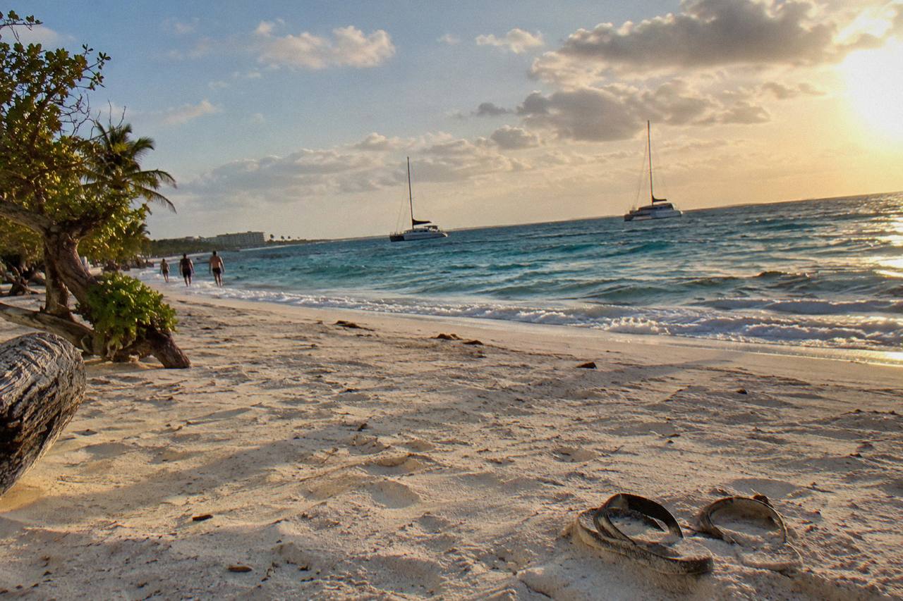 Catamarans at anchor off Eagle Beach, Aruba, under golden-hour trade-wind clouds